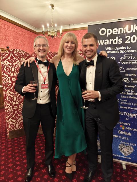 Phil Winder with Hannah Foxwell and Matt Barker beside the OpenUK Awards 2024 banner